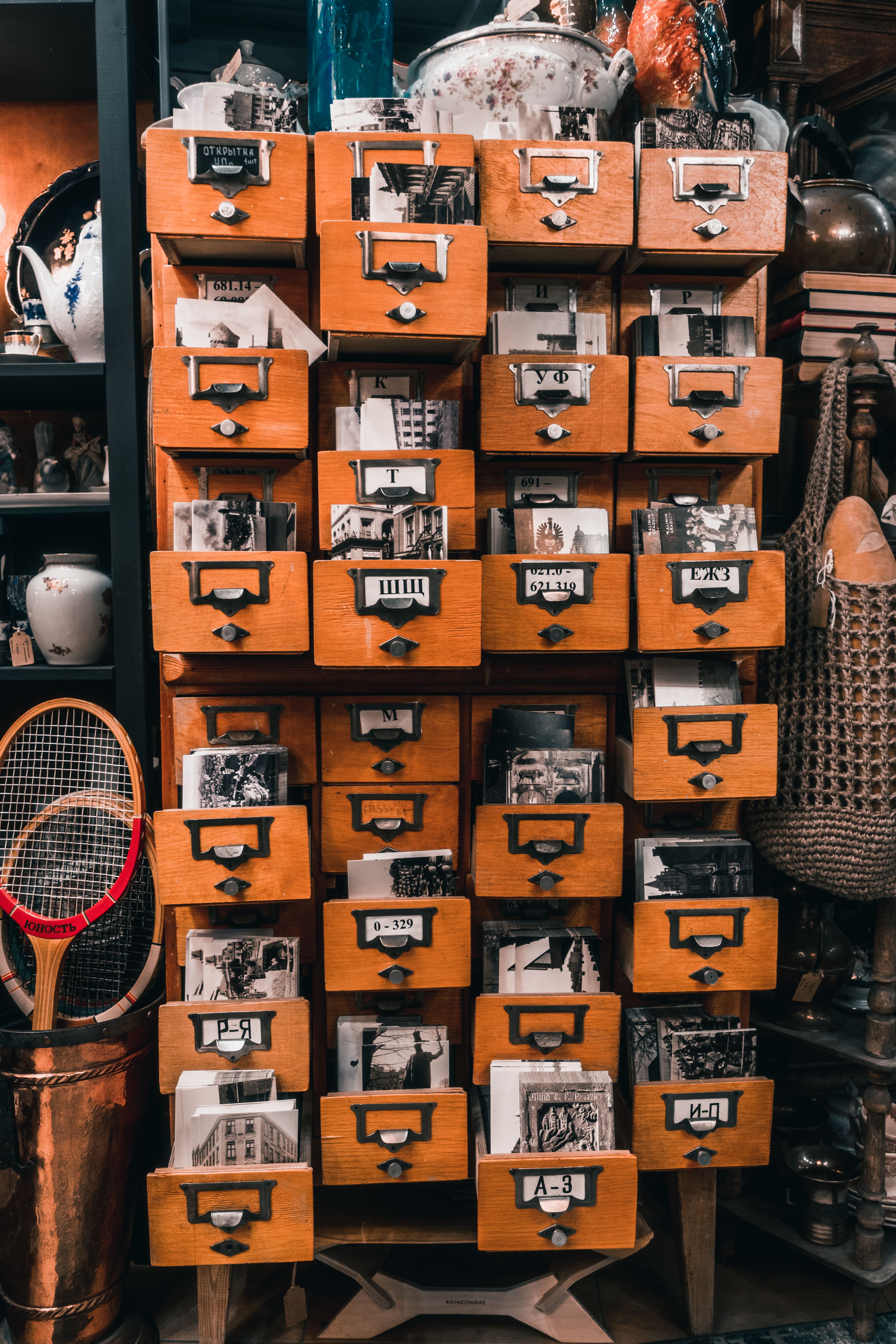 A close-up of a wooden library card catalog with drawer labels