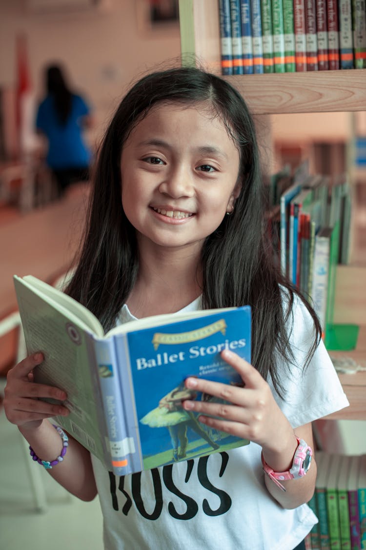 Little Girl Reading Book In Library