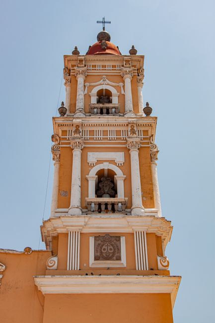 Ornate church tower in Mexico showcasing classical architecture against a clear sky.