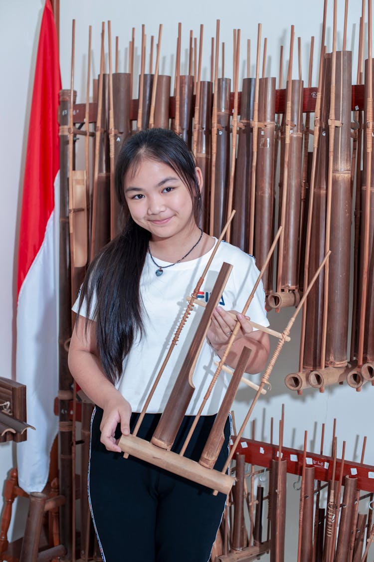 Photo Of A Brunette Holding A Traditional Indonesian Instrument