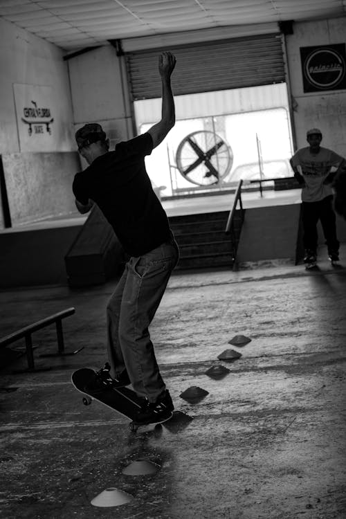 Men Skateboarding in Hall in Black and White