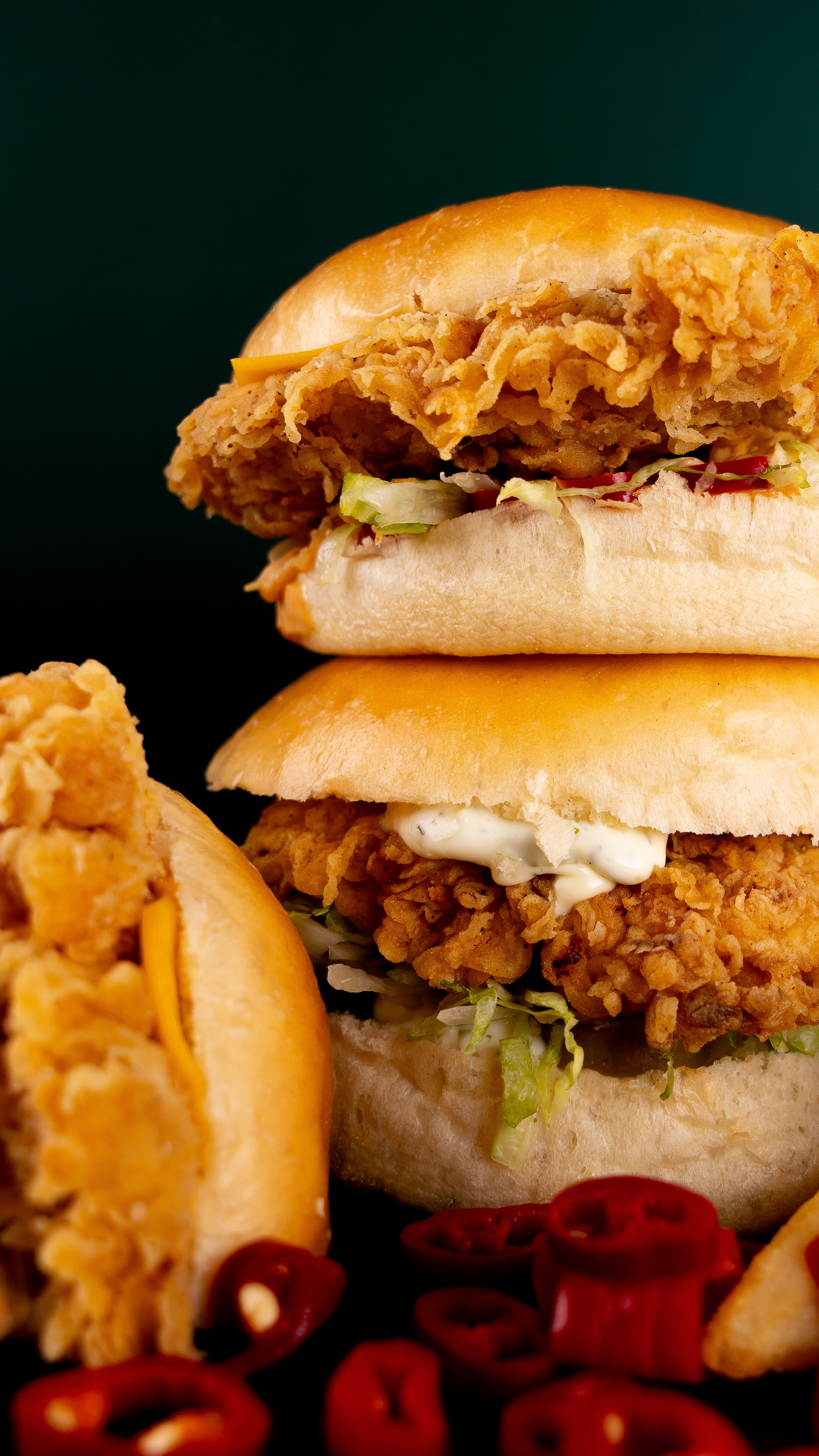 Delicious crispy chicken burgers with fresh chilies on a dark background, perfect fast food indulgence.