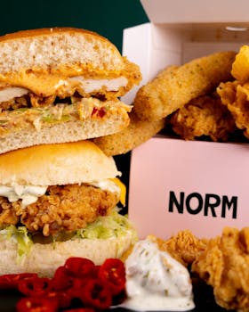 Close-up of a crispy chicken burger with sides, perfect for fast food lovers.
