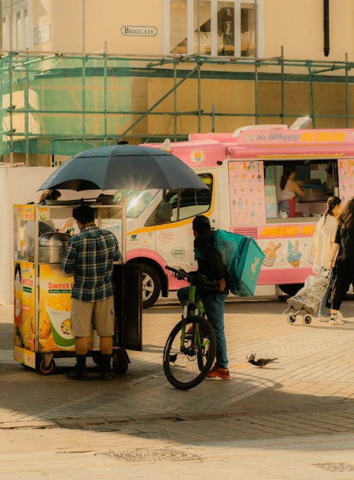 An Ice Cream Truck and a Food Cart on the City Street