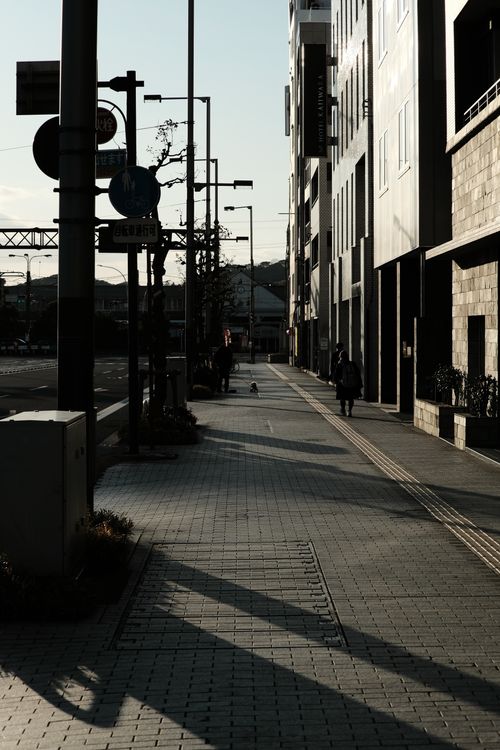 Free A quiet city street with modern architecture and long shadows at dawn. Stock Photo
