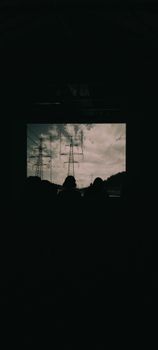 Silhouettes against electricity pylons under a dramatic sky, perfect for themes of energy and industry.