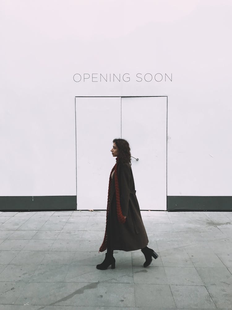 Young Woman Walking Past A White Door