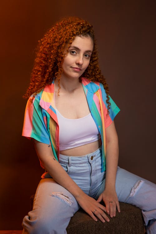 Studio Shot of a Young Woman with Curly Hair Posing in a Casual Outfit 