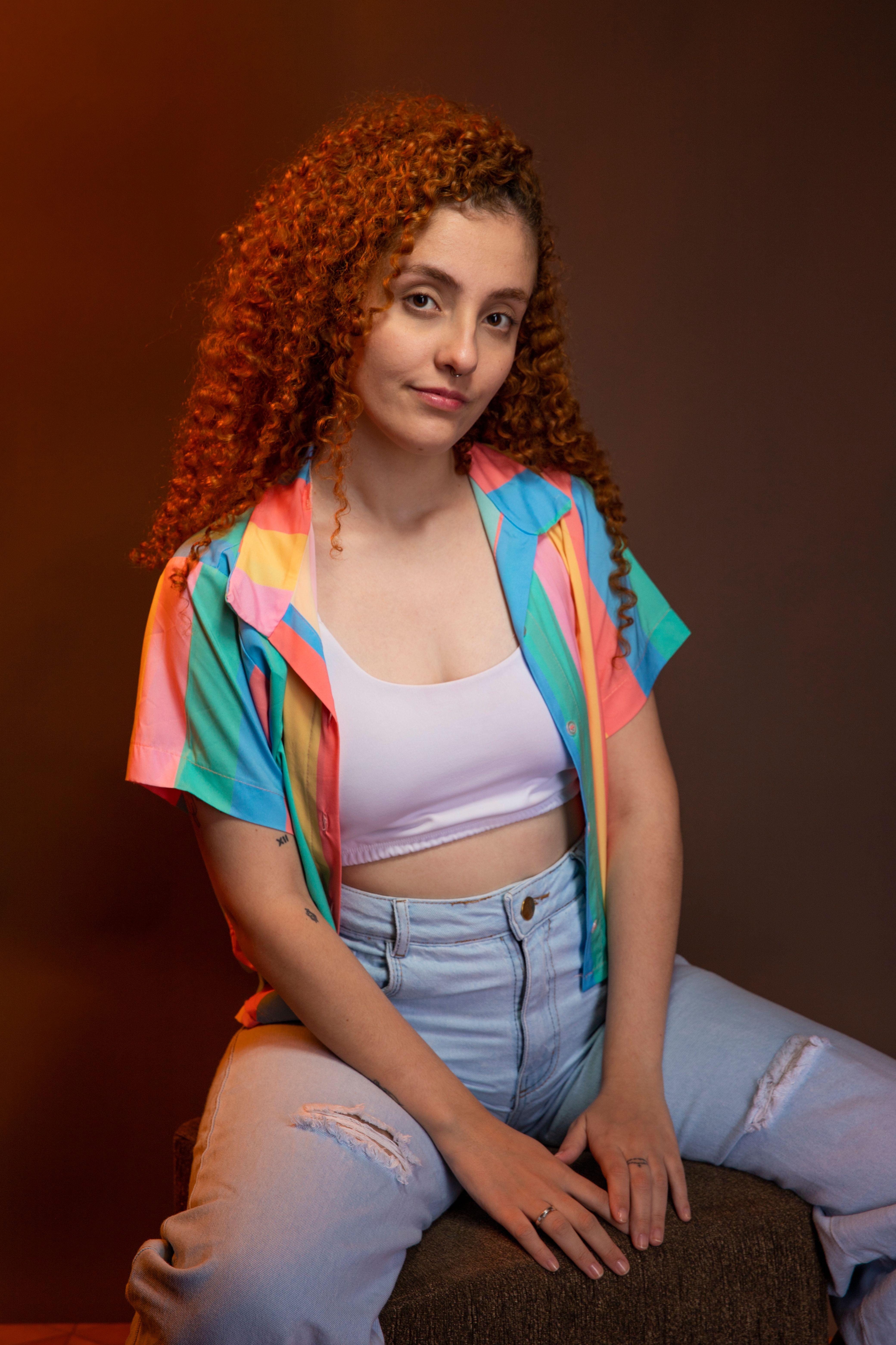Studio Shot of a Young Woman with Curly Hair Posing in a Casual Outfit ...