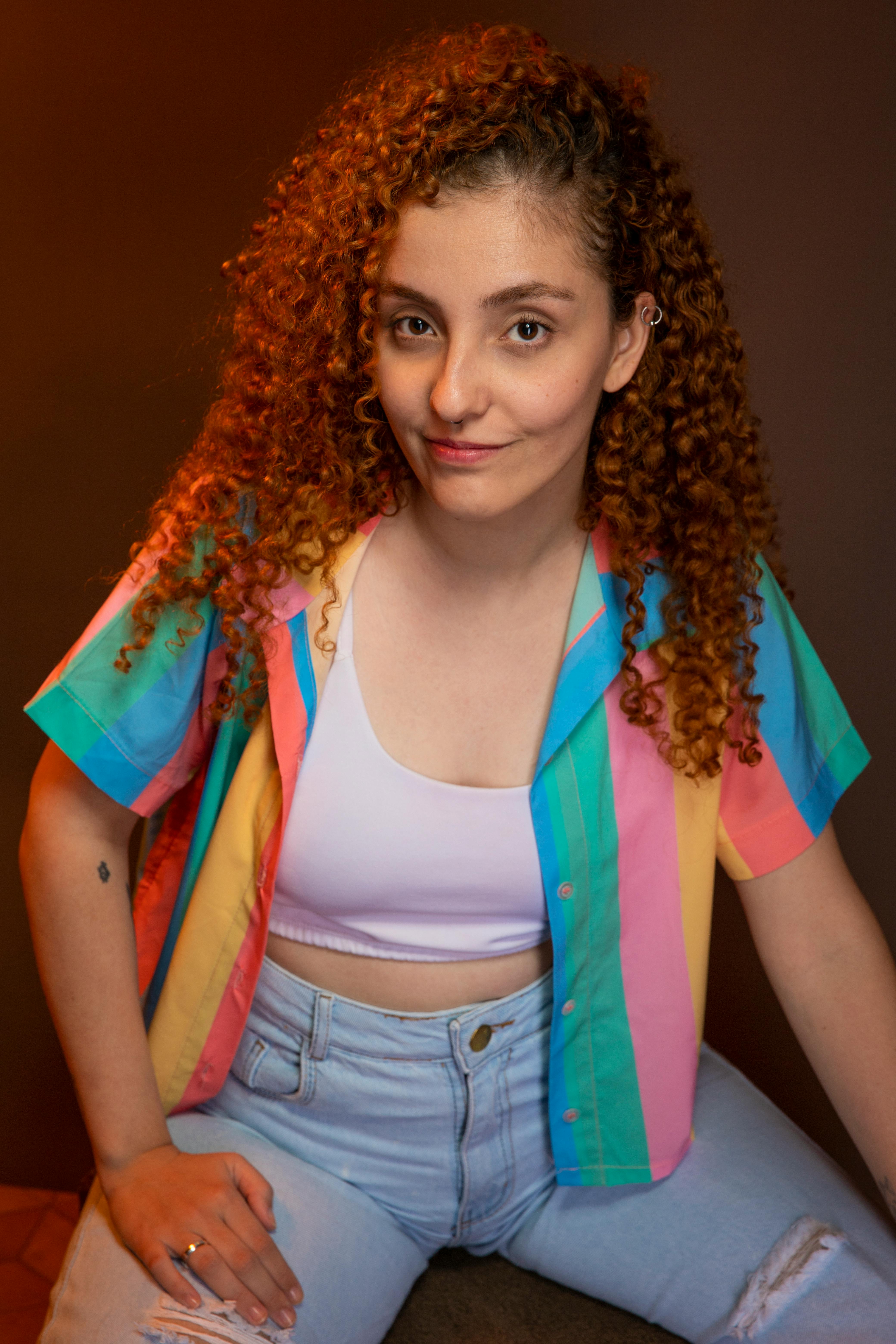 Vibrant portrait showcasing a woman with curly hair in a colorful shirt.