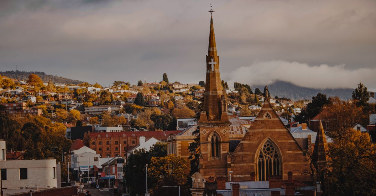 A picturesque view of a historic church and townscape in Hobart, Tasmania with a moody backdrop.
