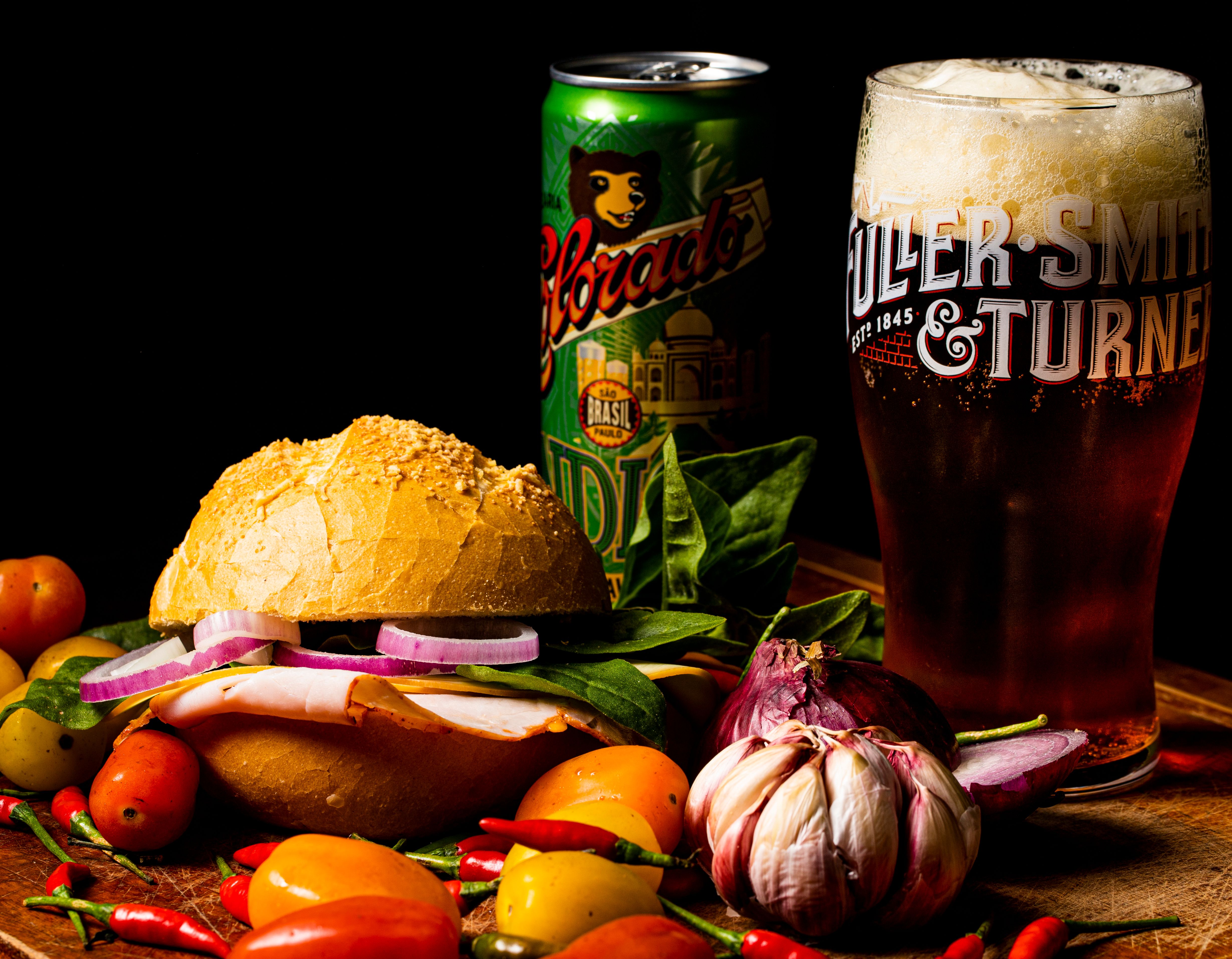 Delicious sandwich with fresh vegetables and a foamy beer, perfect for casual dining.
