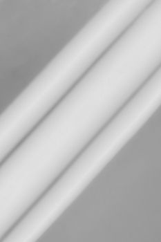 A minimalist grayscale abstract image featuring soft shadows and stripes.