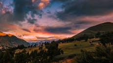 在连绵起伏的山丘和山谷上，捕捉充满活力的日落，展示引人注目的云层和温暖的色彩