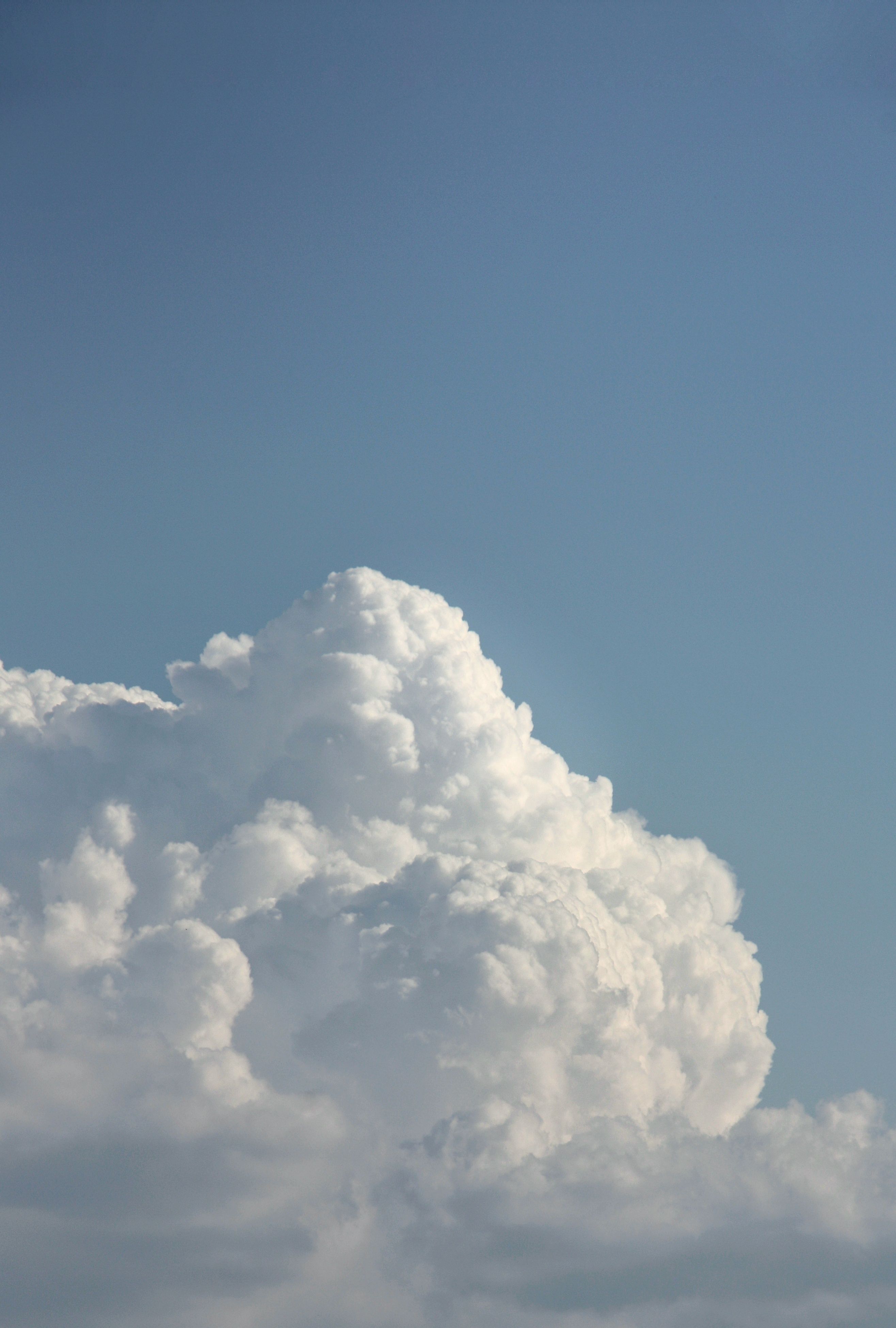 A serene view of large cumulus clouds contrasting with a clear blue sky, perfect for calming visuals.