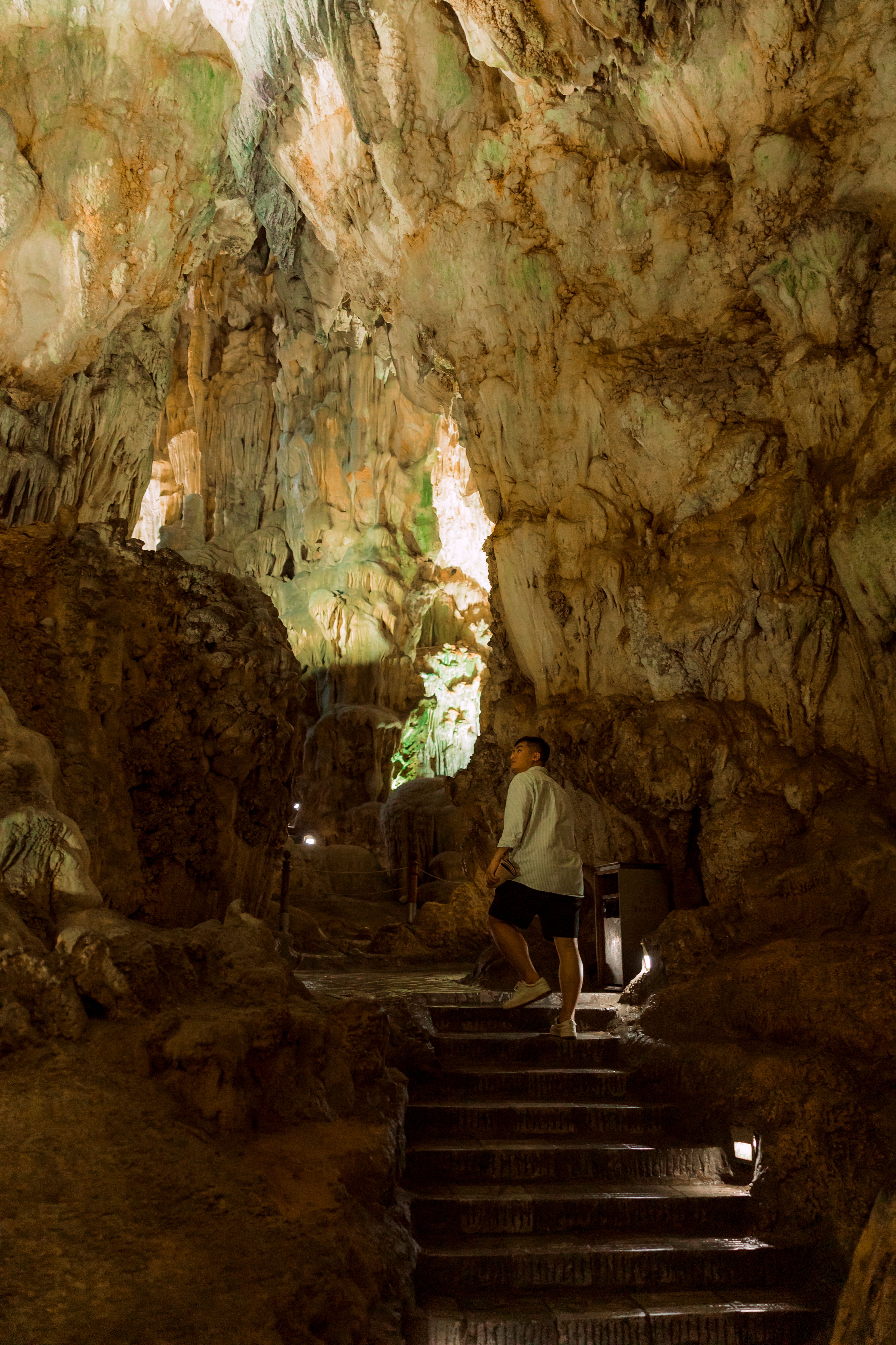 Tourist exploring the intricate rock formations of Thien Cung Cave, Vietnam.