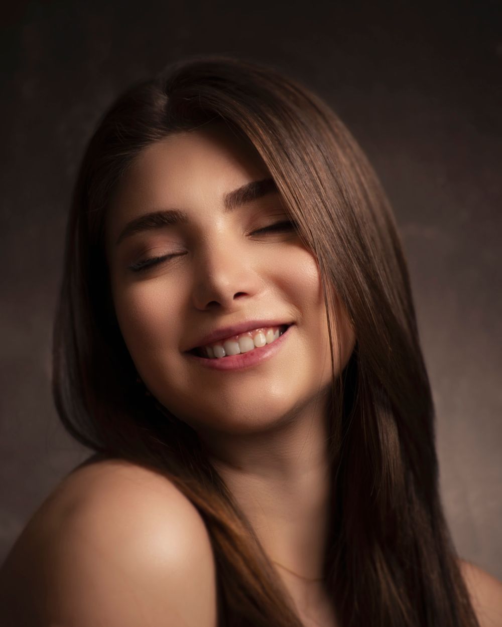 A smiling woman with healthy-looking skin and long, glossy hair