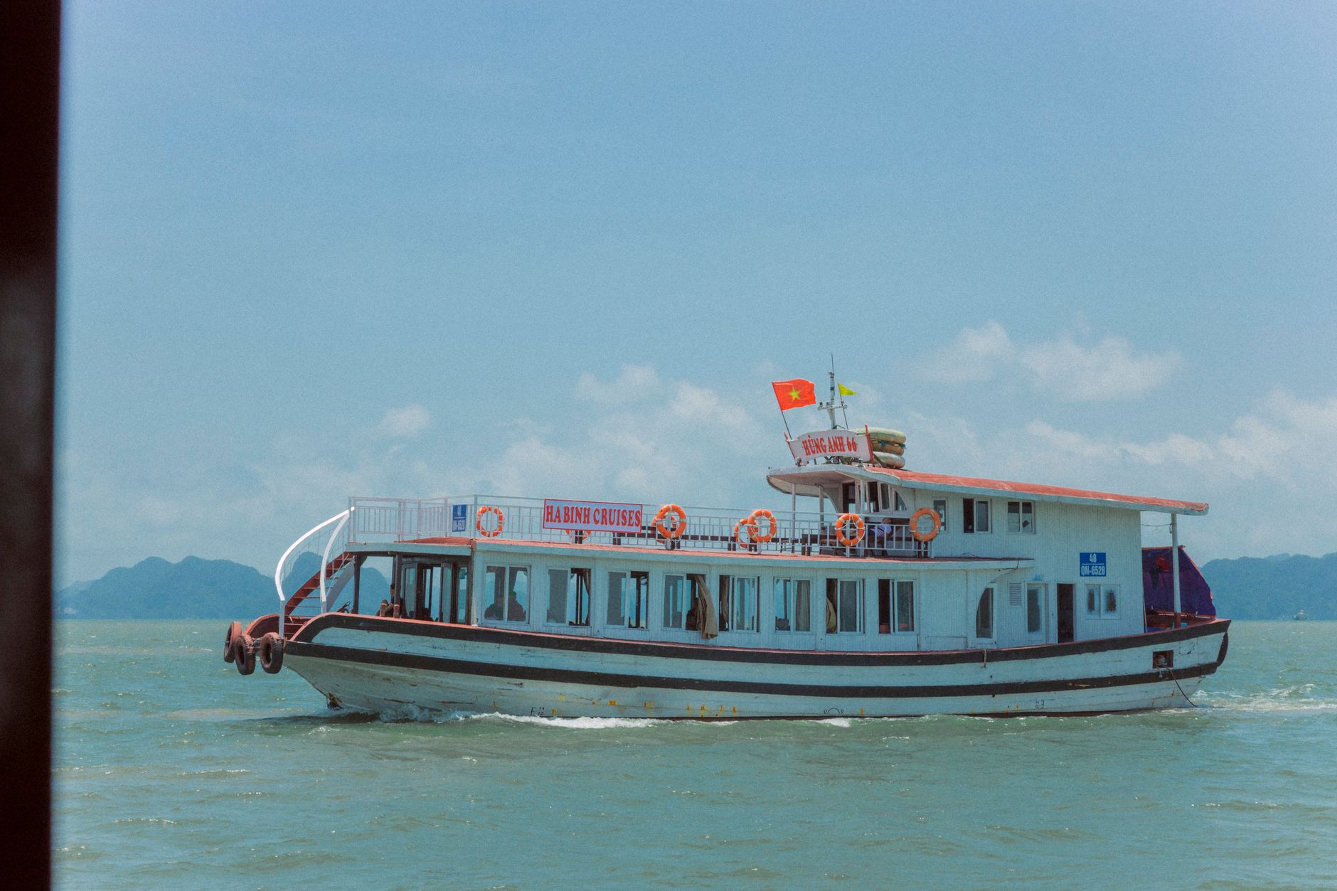 वियतनाम की Halong Bay में नौकायन करते हुए एक क्रूज़ बोट का सुंदर दृश्य।