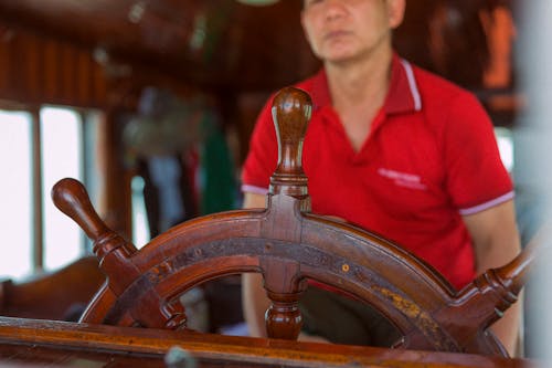 Man Standing behind the Helm 