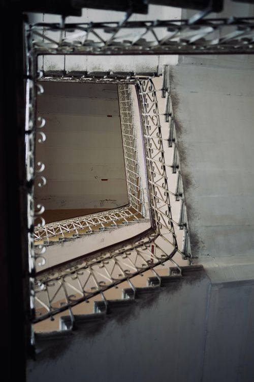Free Captivating low angle view of a spiral staircase interior with intricate handrails. Stock Photo
