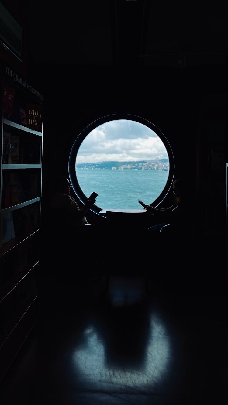 People By Table On Vessel In Darkness