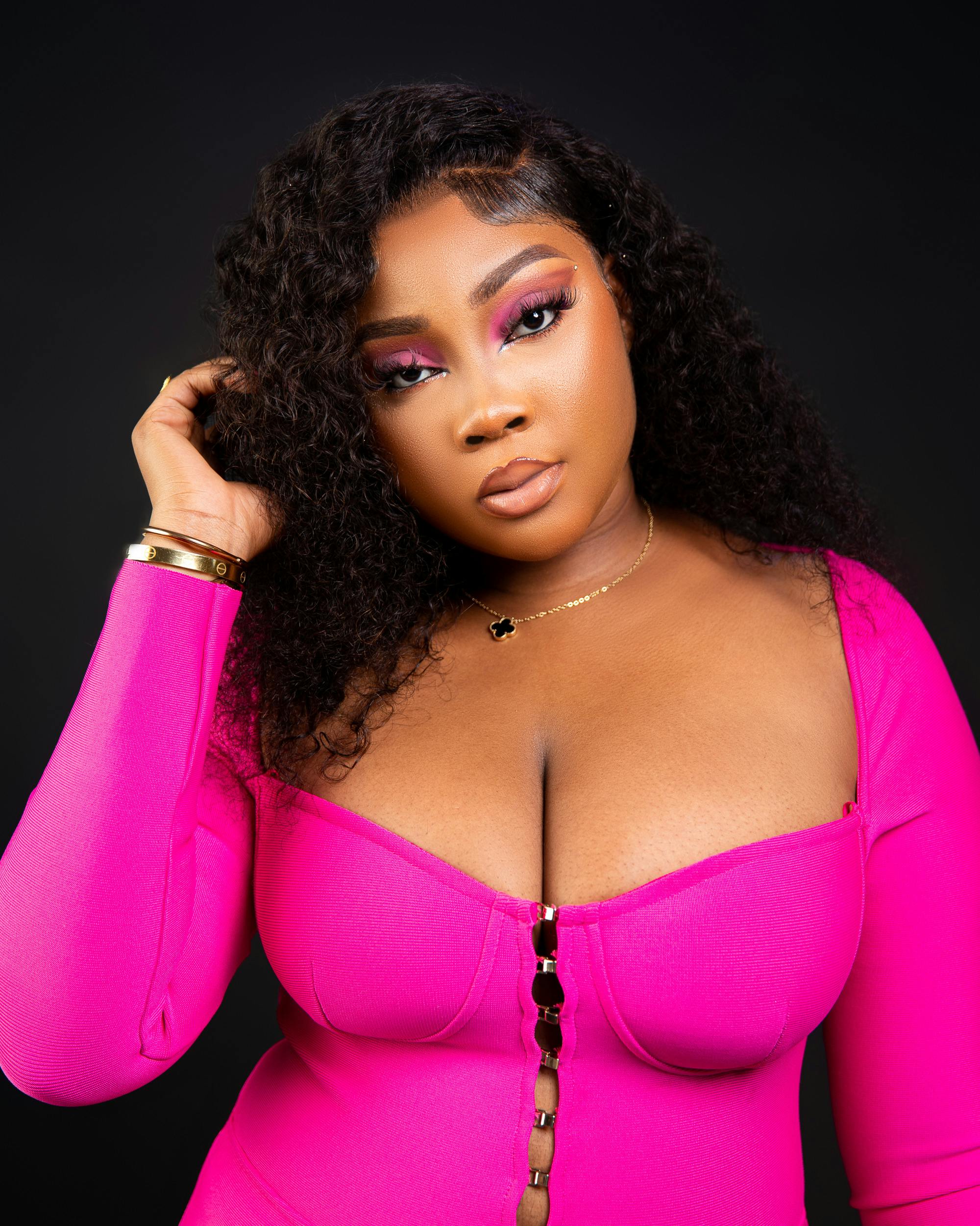 Elegant portrait of a young woman in pink, showcasing vibrant fashion and style.