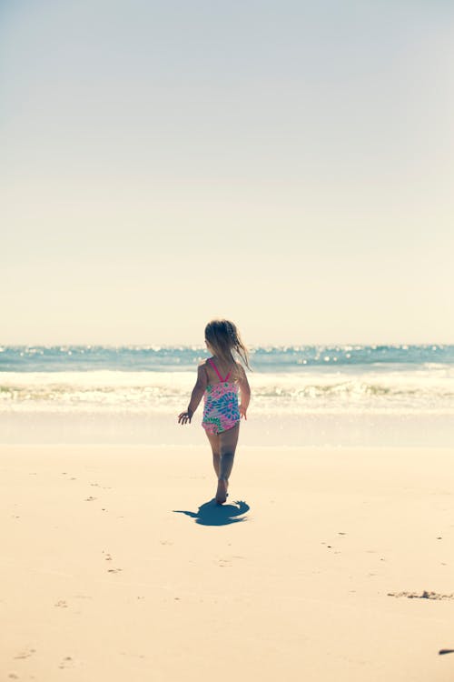 Girl Standing On Brown Sand