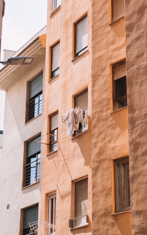 Facade of a Residential Building in City with Laundry Hanging out of the Window 