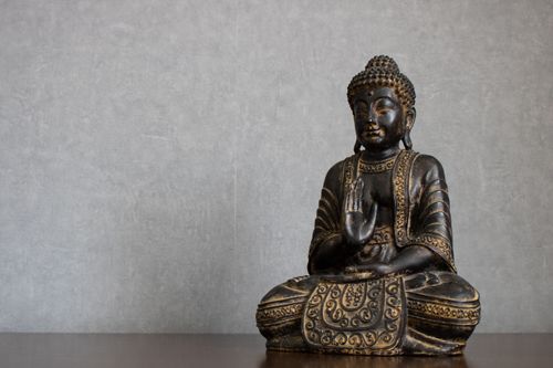 Free Elegant bronze Buddha statue representing peace and spirituality in meditation setting. Stock Photo