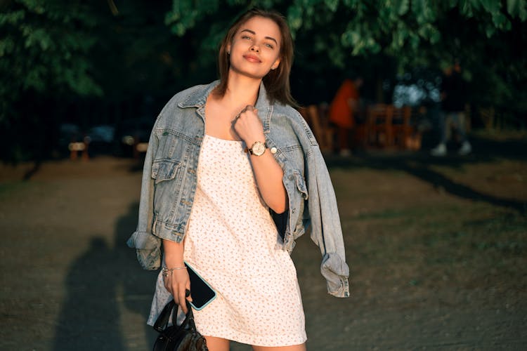 Smiling Woman In Jean Jacket And Dress