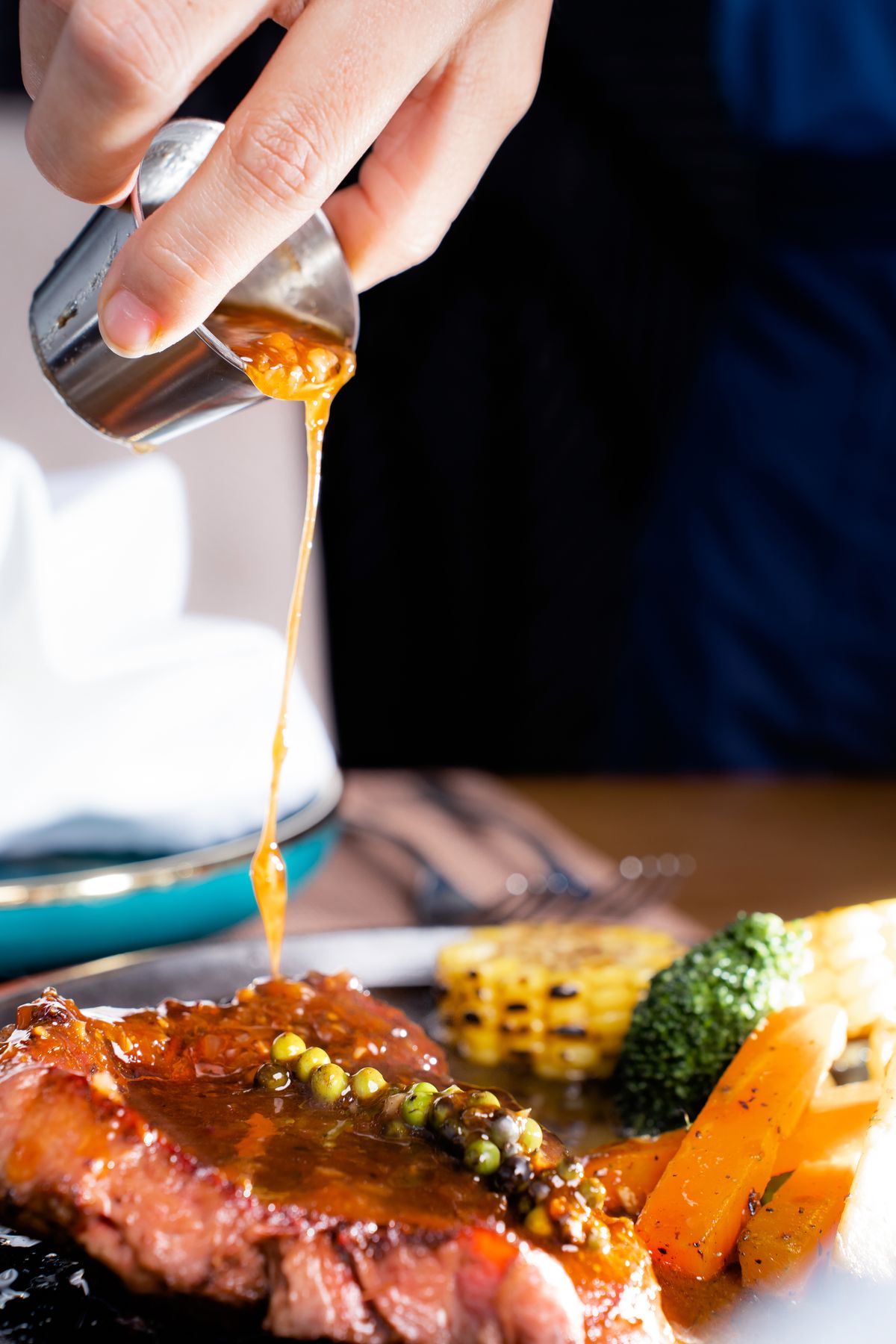 Gravy being poured over a roast, a make-ahead Thanksgiving essential
