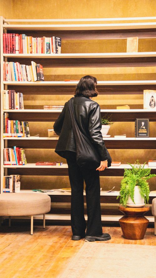 Free A person in a leather jacket browsing books in a cozy Istanbul bookstore. Stock Photo
