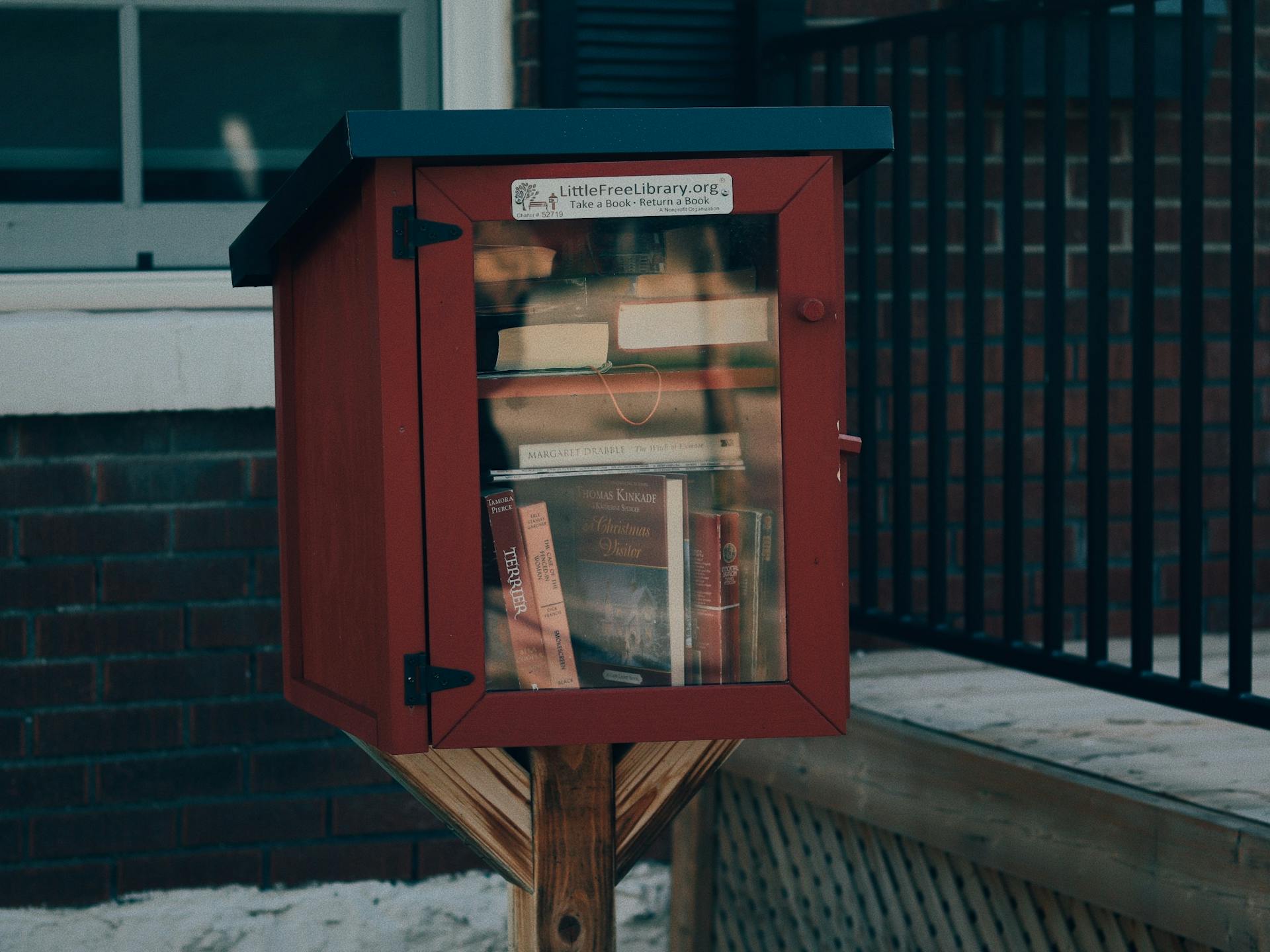 A Wooden Box with Free Books in front of a Building in City