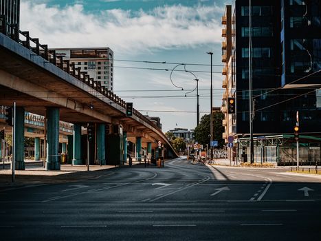 Lively urban scene featuring a modern overpass and surrounding skyscrapers on a sunny day.