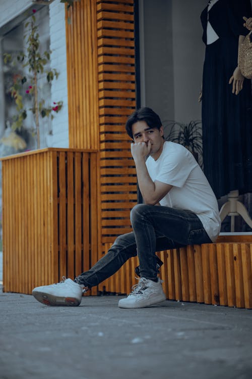 Young Man in a Casual Outfit Sitting Outside 
