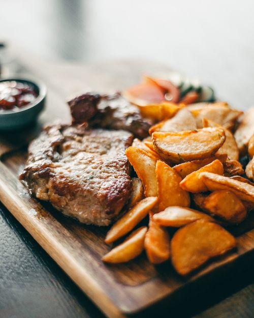 Free Savor a hearty meal of juicy steak with crispy potato wedges, perfect for dinner. Stock Photo