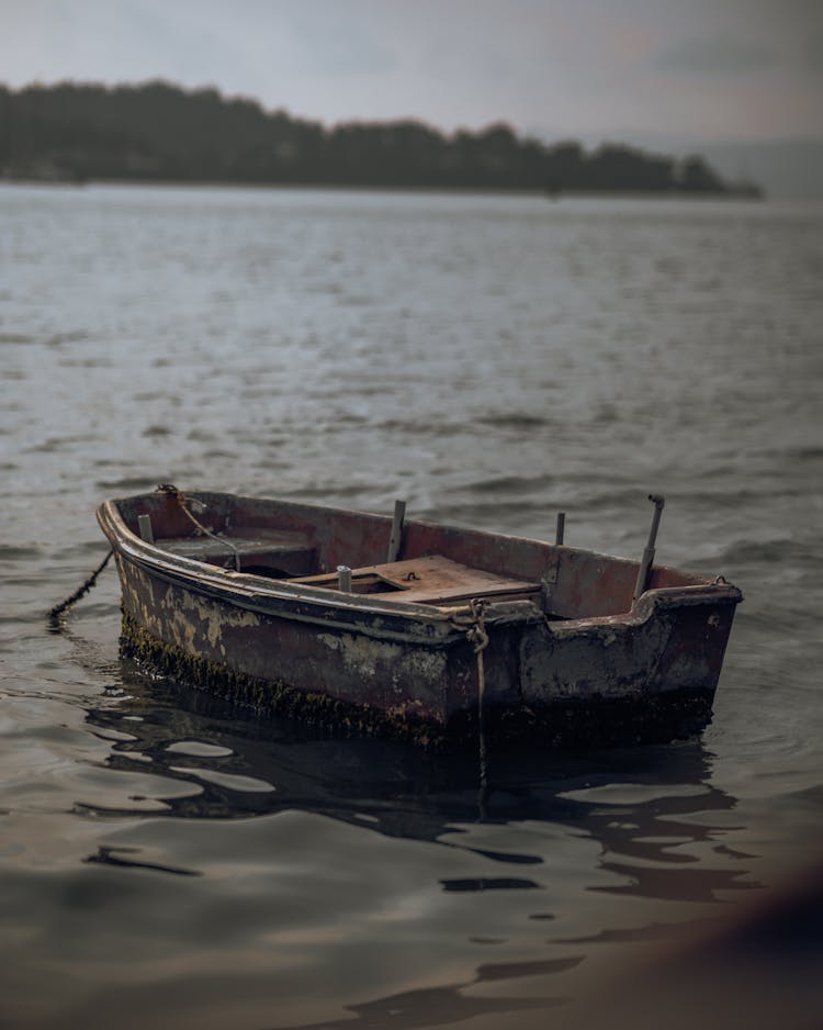 An Old Dirty Boat Moored On The Shore 