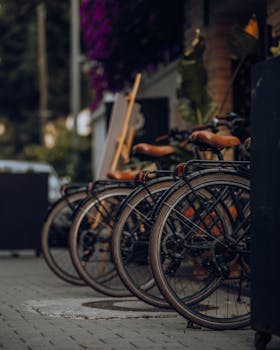 Vertical shot of bicycles lined up on a city sidewalk, perfect urban transport scene.
