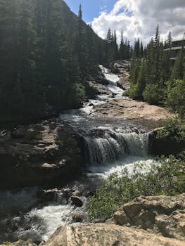 在科罗拉多州布雷肯里奇的蔚蓝天空下，郁郁葱葱的绿色植物环绕着令人惊叹的瀑布