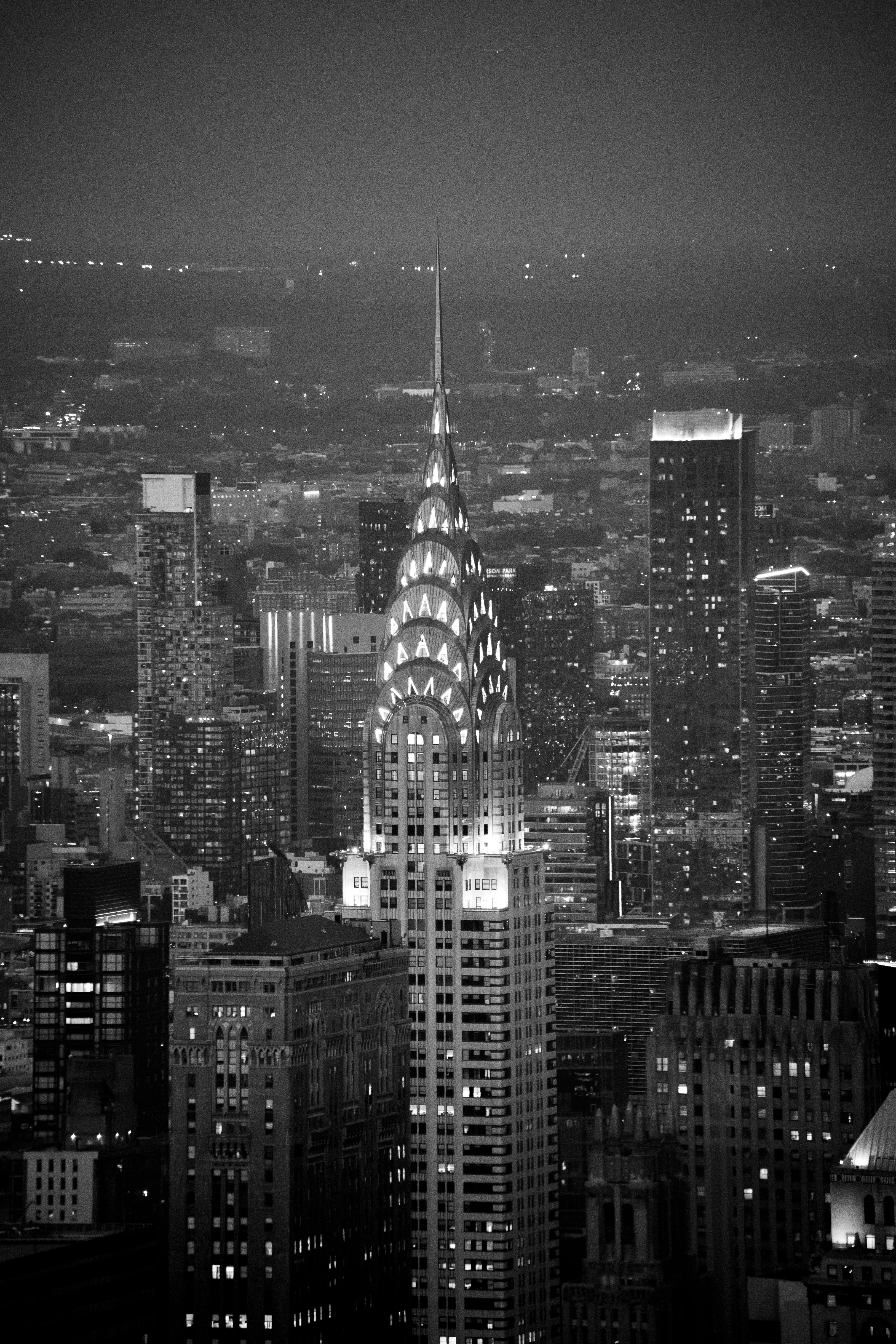 A stunning black and white aerial view of the Chrysler Building and New York City skyline at night.