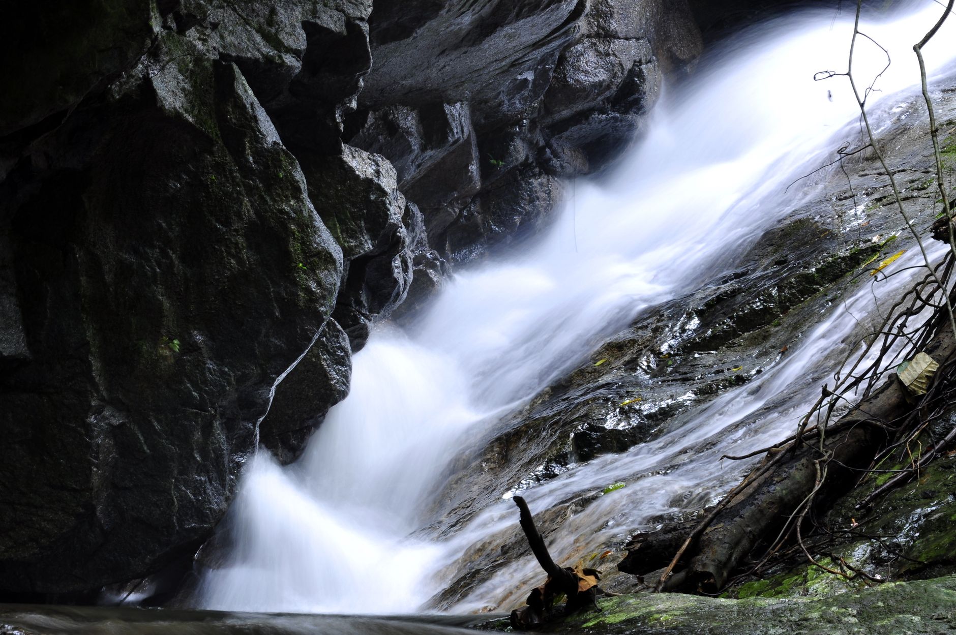 Smooth flowing waterfall in lush Hulu Langat forest, showcasing serene nature and beauty.