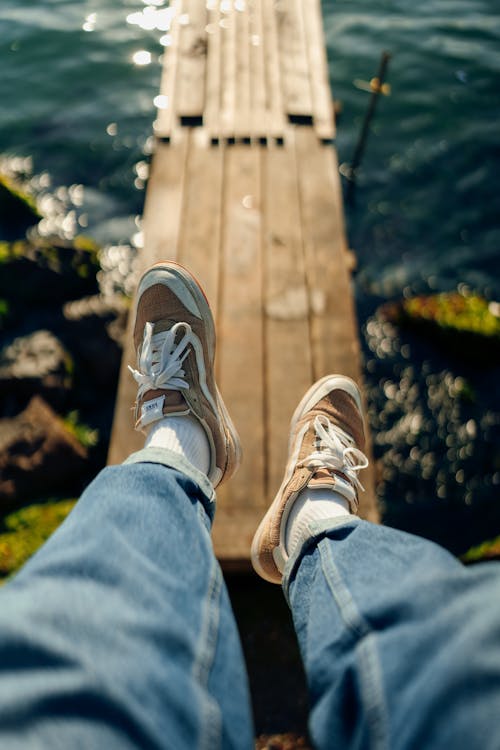 Photo of Legs in Jeans and Sneakers
