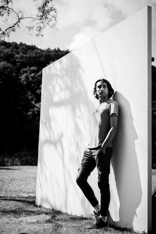 Man Standing against a White Wall Outdoors 