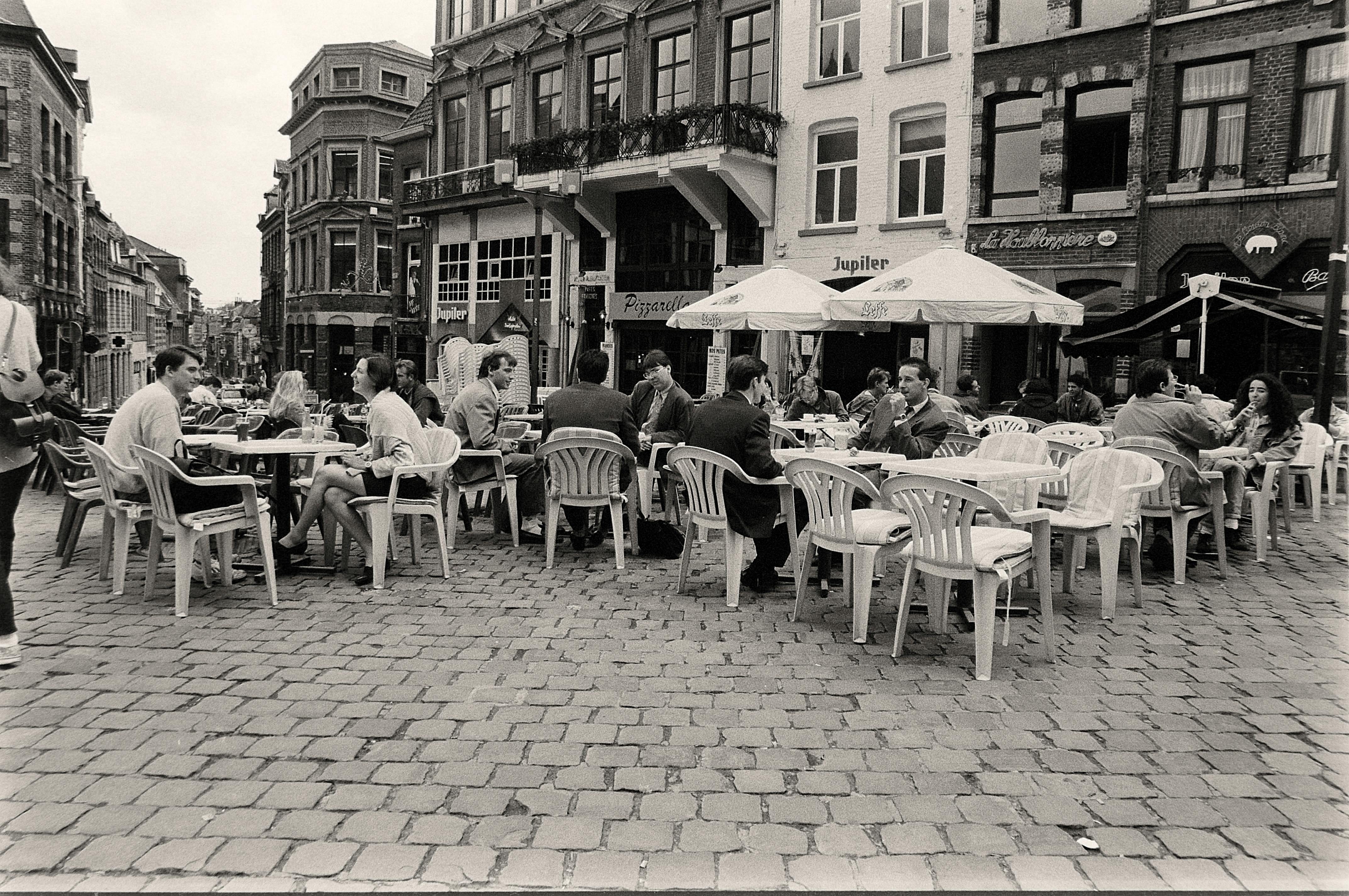 Cozy outdoor city cafe with people socializing in an urban setting.