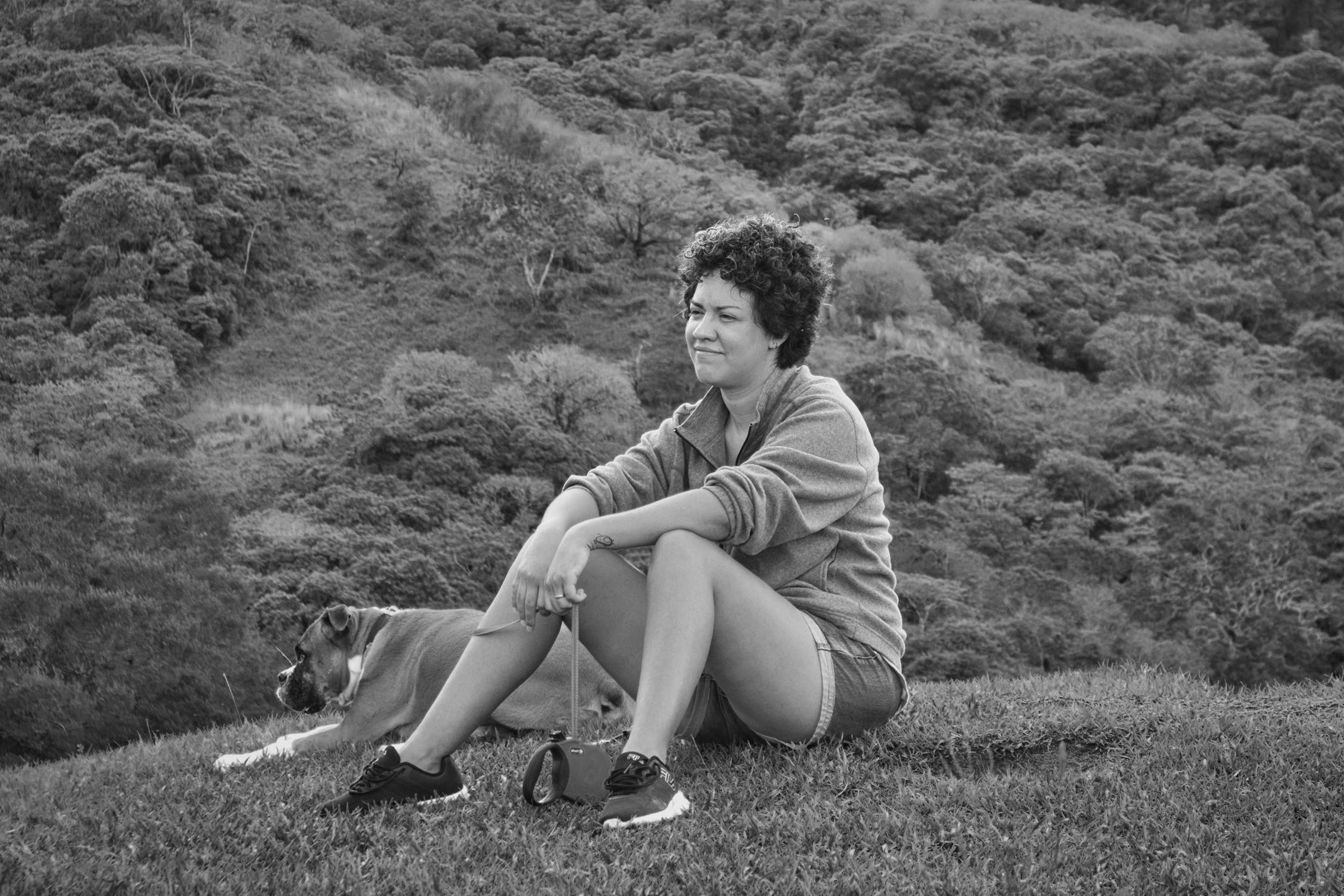 Woman with dog enjoying tranquility in Costa Rican hills, black and white.