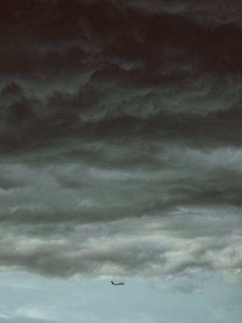 An Airplane Below Storm Clouds 