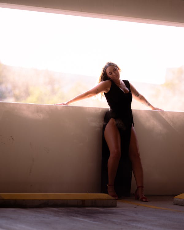 Woman in Black Dress Leaning on Wall