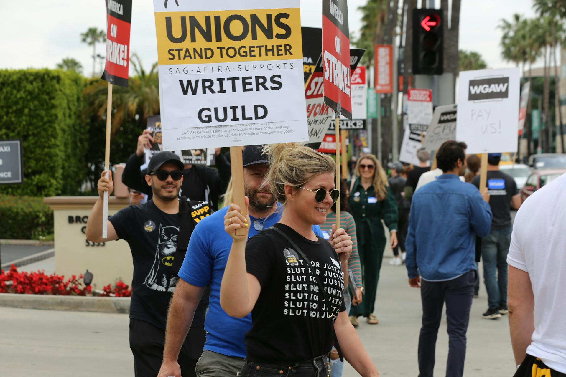 Group of protesters with placards supporting Writers Guild on a street demonstration.