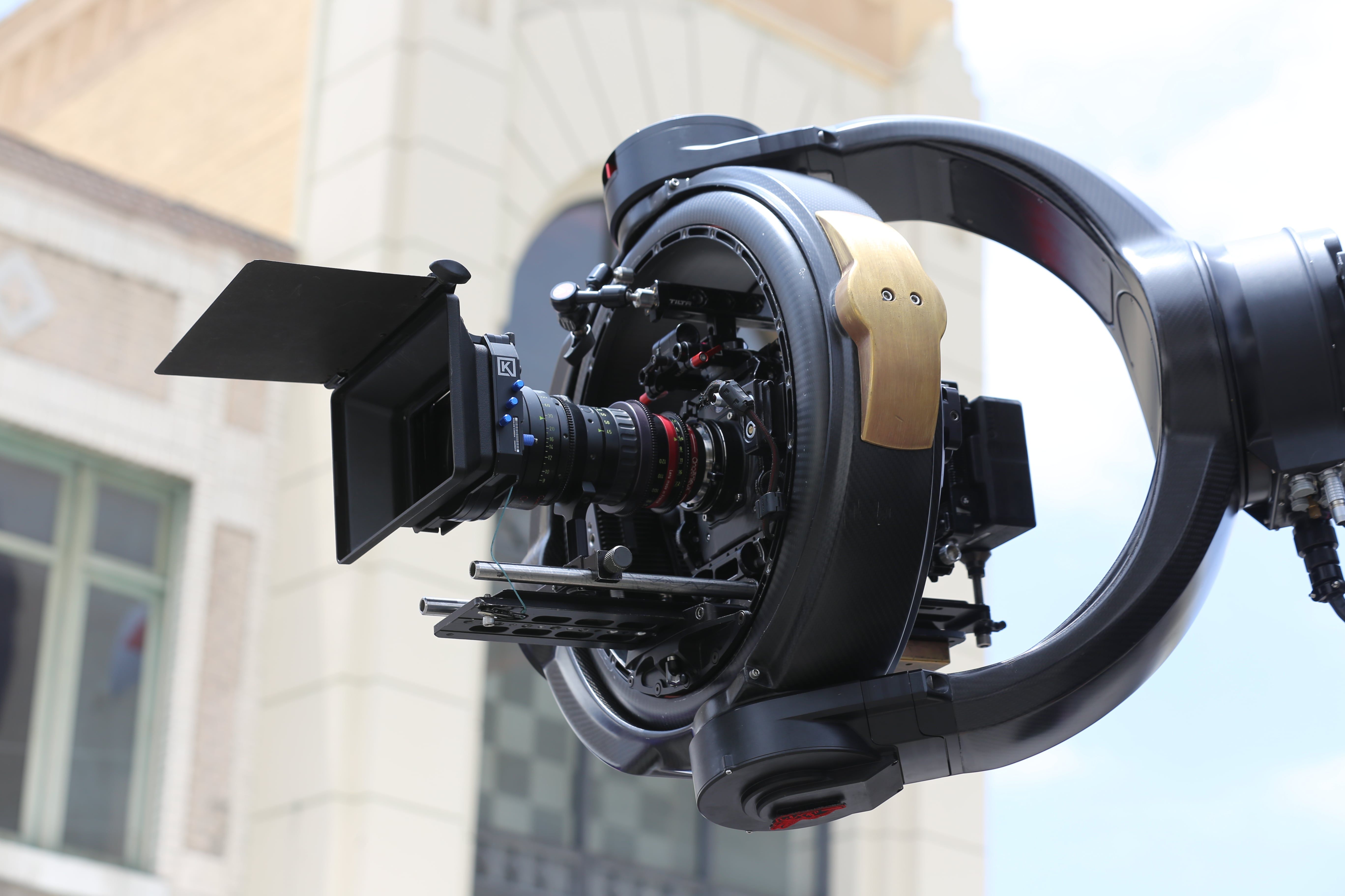 Detailed shot of a professional cinema drone camera rig with lens and gimbal outdoors.