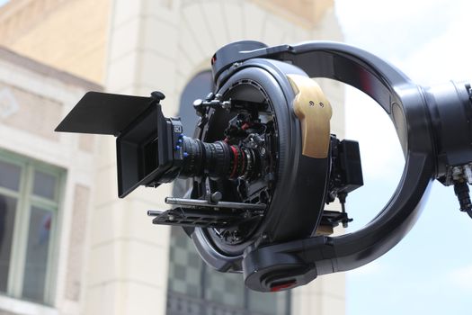 Detailed shot of a professional cinema drone camera rig with lens and gimbal outdoors.